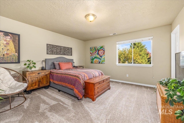 bedroom featuring a textured ceiling and light colored carpet