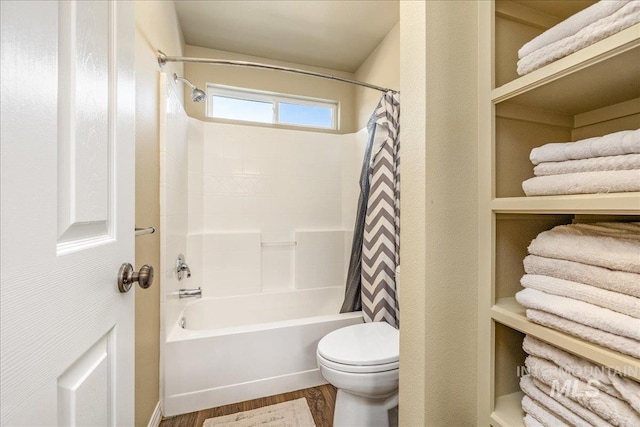 bathroom with shower / bath combo with shower curtain, hardwood / wood-style floors, and toilet