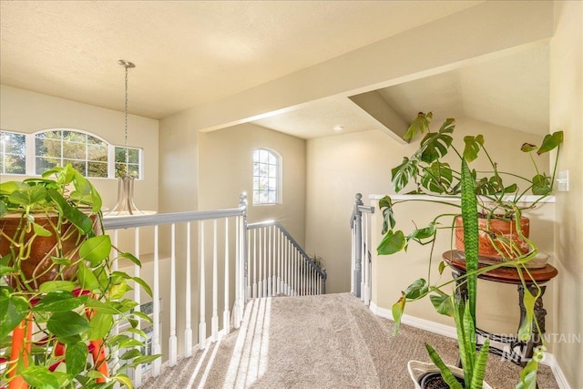 hallway with vaulted ceiling with beams and carpet