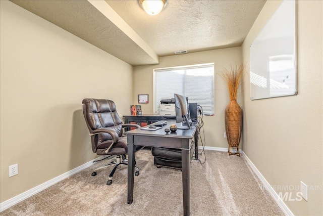 carpeted office featuring a textured ceiling