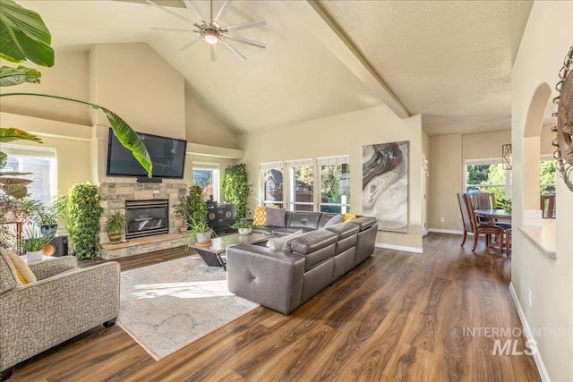 living room with ceiling fan, dark hardwood / wood-style floors, plenty of natural light, and a fireplace