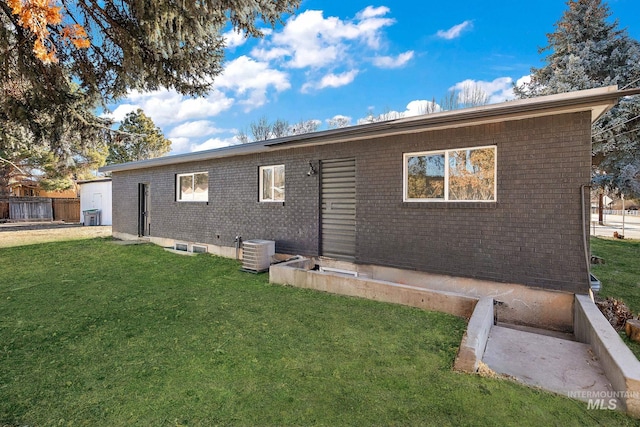 5338 W Spaulding St, Boise, ID 83705 - rear view of house with brick siding, a lawn, and central air condition unit
