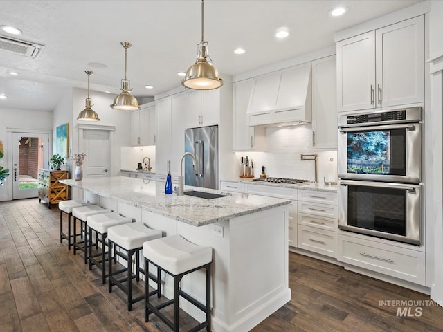 2510 N 24th St, Boise, ID 83702 - kitchen featuring stainless steel appliances, dark wood-style flooring, custom range hood, decorative backsplash, and recessed lighting