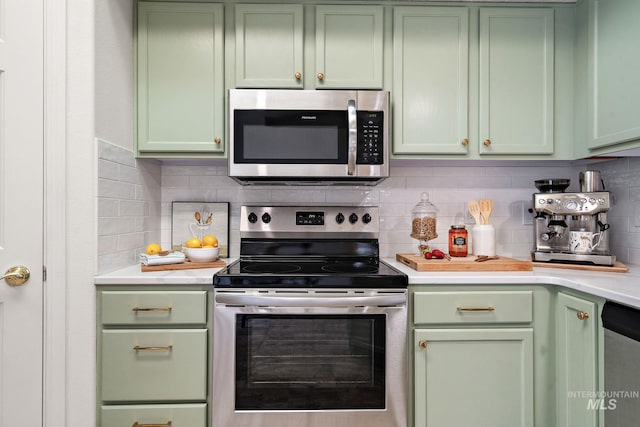 kitchen featuring appliances with stainless steel finishes, backsplash, and green cabinetry