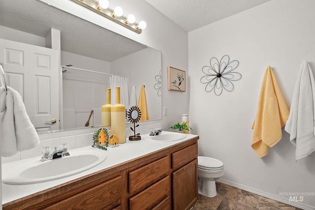 bathroom with a shower with curtain, vanity, a textured ceiling, and toilet