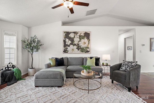 living room featuring hardwood / wood-style flooring, ceiling fan, and vaulted ceiling