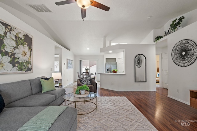 living room featuring hardwood / wood-style flooring, ceiling fan, and vaulted ceiling