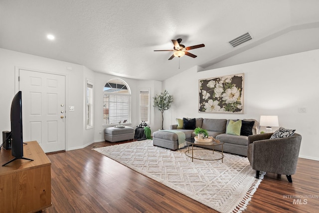 living room featuring ceiling fan, lofted ceiling, dark hardwood / wood-style flooring, and a textured ceiling