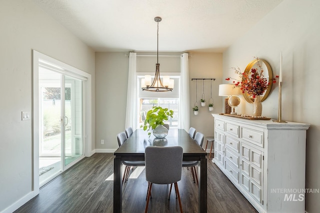 dining room featuring a notable chandelier, a textured ceiling, dark hardwood / wood-style floors, and plenty of natural light