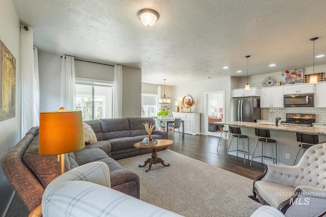 living room with a textured ceiling and dark hardwood / wood-style flooring