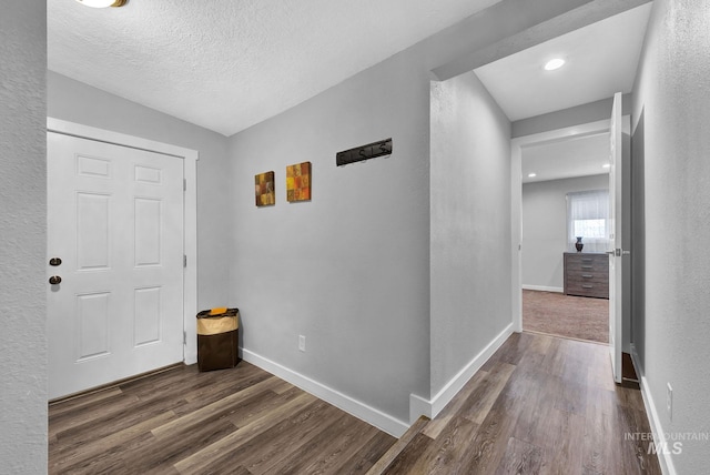 hallway with dark hardwood / wood-style flooring and a textured ceiling