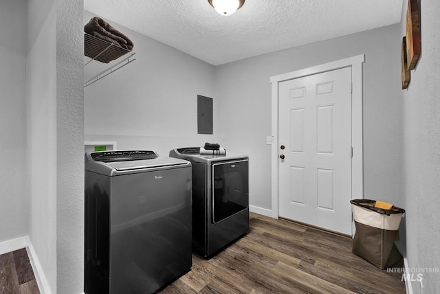 washroom featuring dark hardwood / wood-style flooring, electric panel, independent washer and dryer, and a textured ceiling