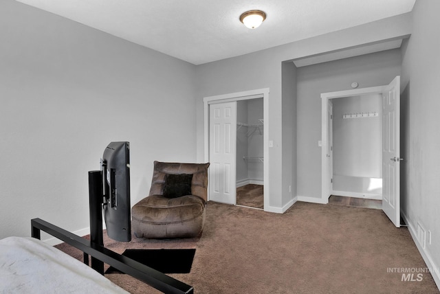 carpeted bedroom featuring a walk in closet and a closet