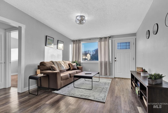 living room with dark wood-type flooring and a textured ceiling