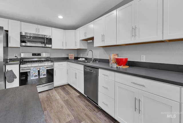 kitchen featuring sink, stainless steel appliances, white cabinets, and light wood-type flooring