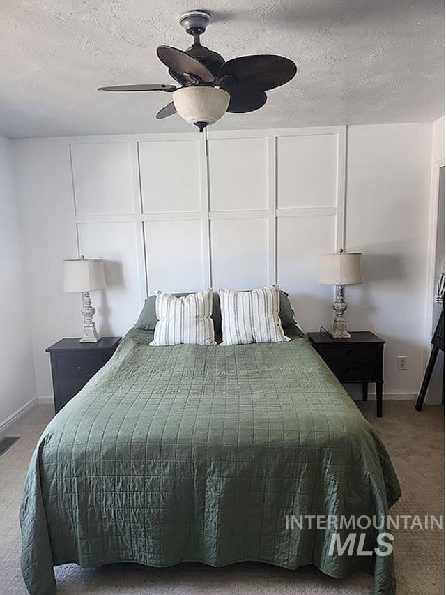 297 N 4228 E, Rigby, ID 83442 - carpeted bedroom with a textured ceiling and ceiling fan