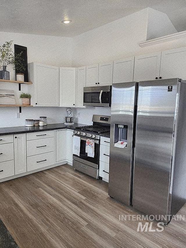 297 N 4228 E, Rigby, ID 83442 - kitchen featuring appliances with stainless steel finishes, dark countertops, dark wood-style floors, and white cabinetry