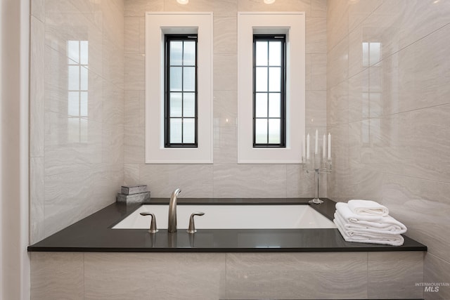 bathroom featuring tile walls and a bathtub