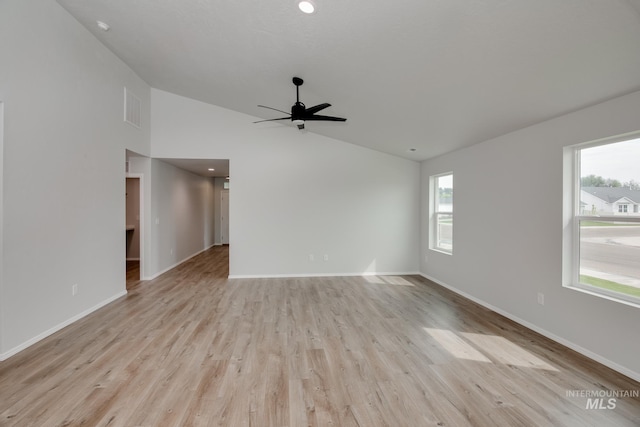 spare room with light hardwood / wood-style floors, high vaulted ceiling, and ceiling fan