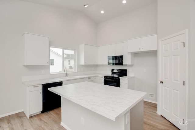 kitchen featuring a center island, high vaulted ceiling, black appliances, white cabinets, and sink