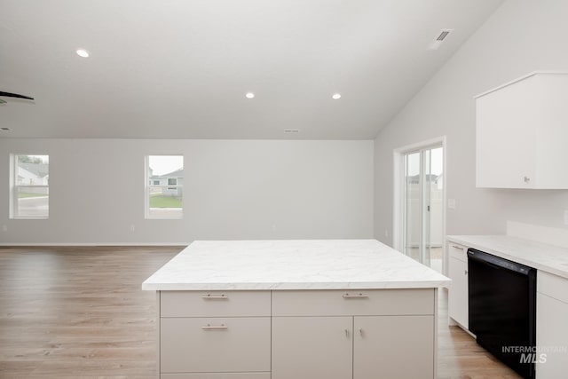 kitchen with black dishwasher, light hardwood / wood-style floors, white cabinetry, and a healthy amount of sunlight