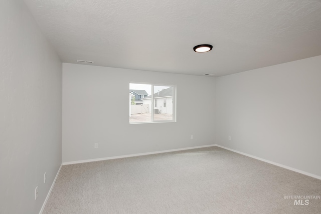 spare room featuring carpet floors and a textured ceiling