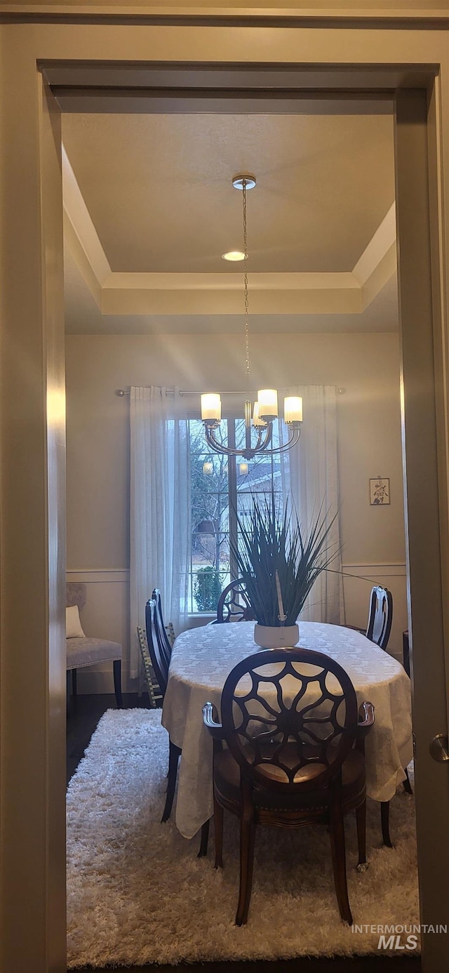 dining area with a raised ceiling and an inviting chandelier