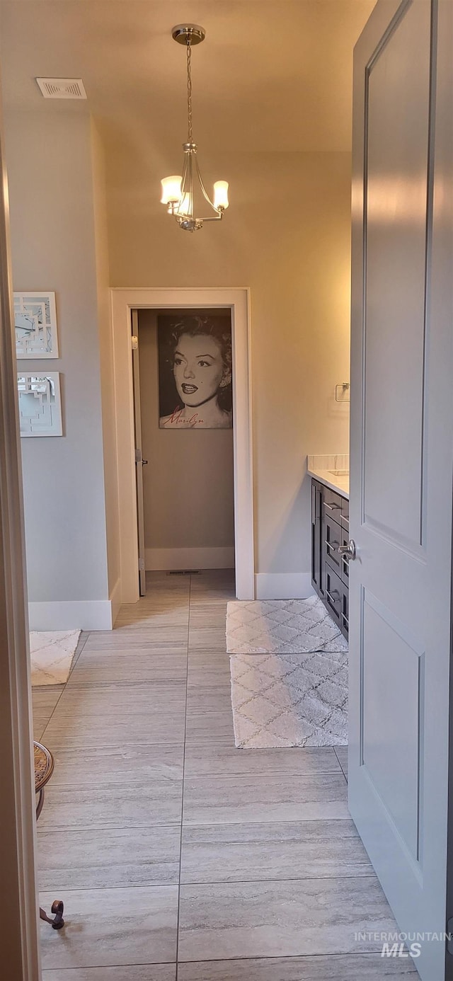 hall featuring an inviting chandelier and light wood-type flooring