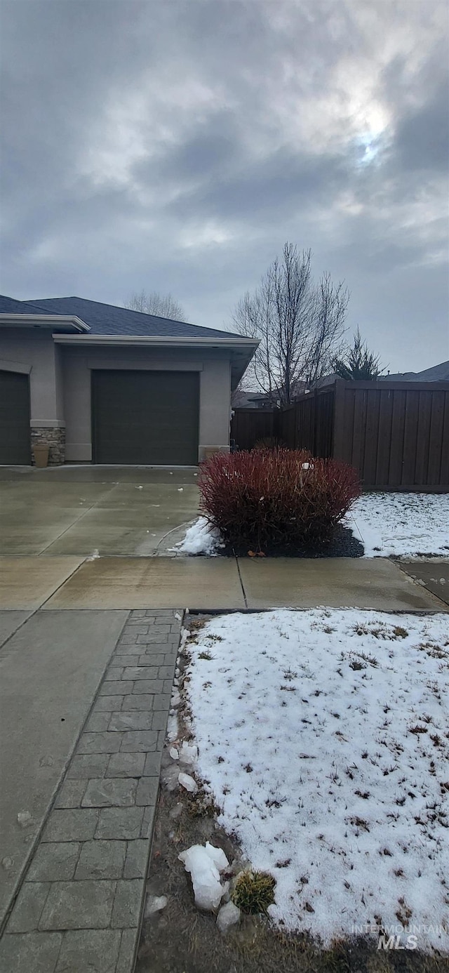 view of snow covered exterior featuring a garage