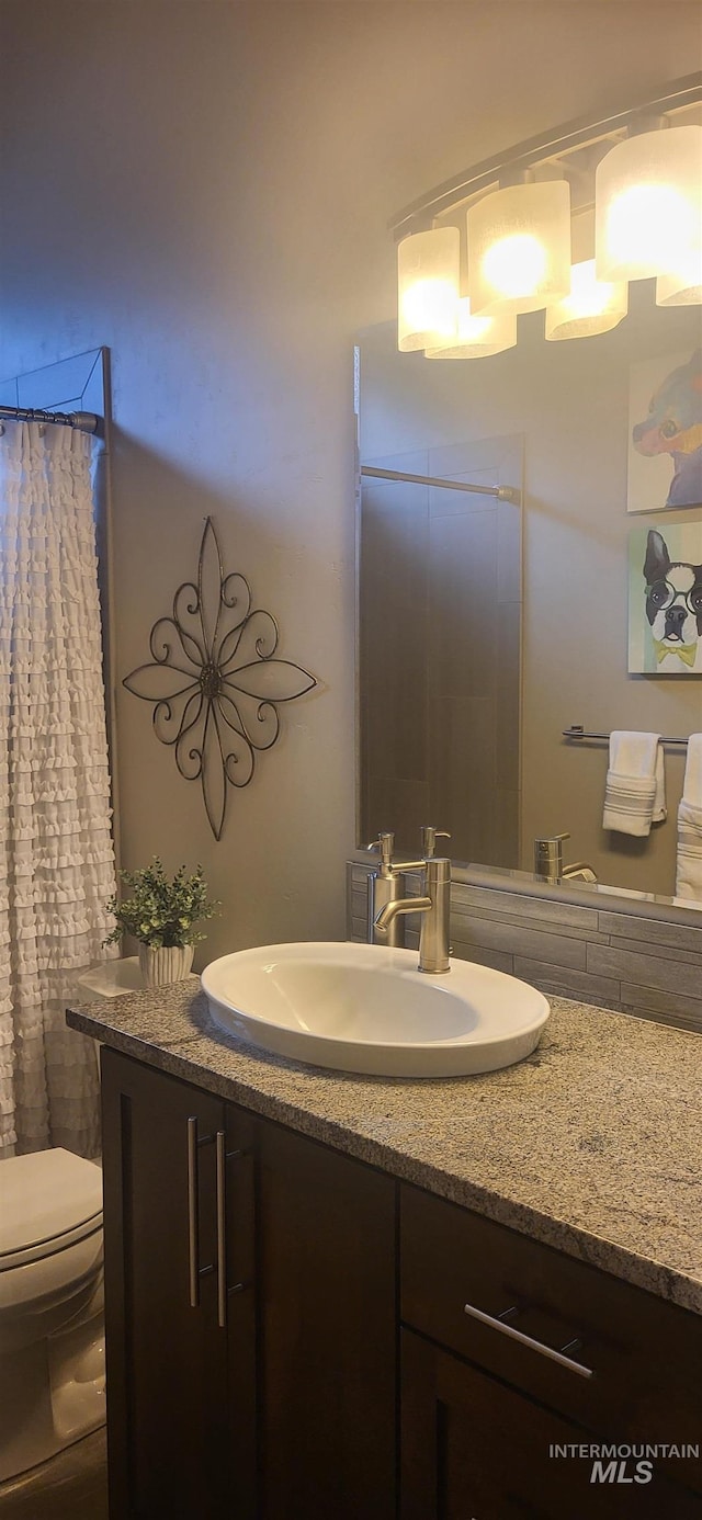 bathroom with vanity, a shower with shower curtain, and toilet