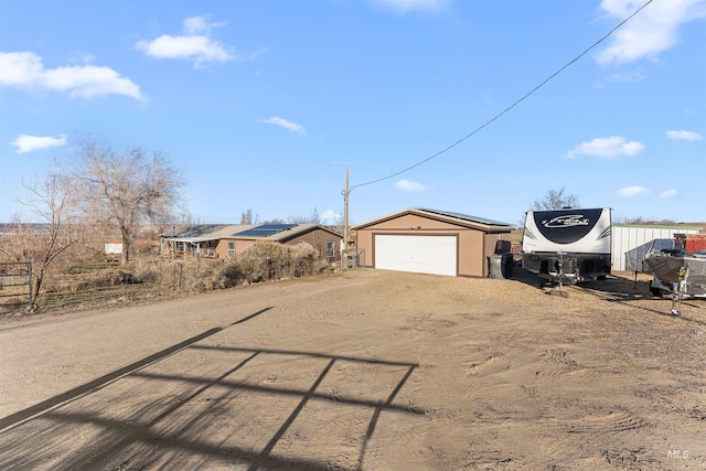 view of front of property featuring an outdoor structure and dirt driveway