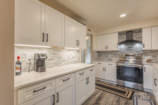 kitchen featuring white cabinetry, electric range, dark hardwood / wood-style flooring, wall chimney range hood, and backsplash