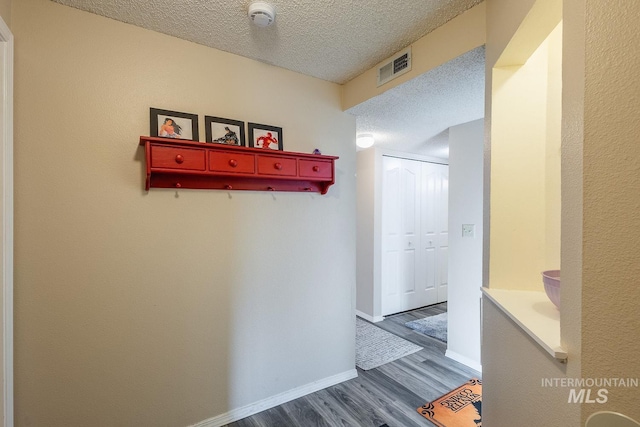 corridor featuring dark hardwood / wood-style floors and a textured ceiling