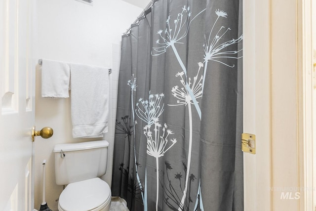 bathroom with curtained shower and toilet