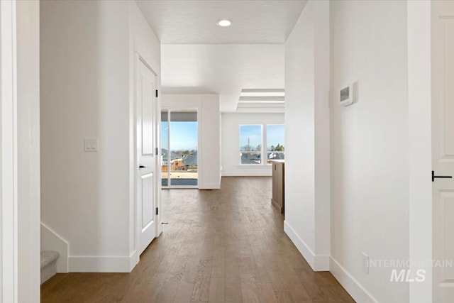 corridor with recessed lighting, wood finished floors, and baseboards