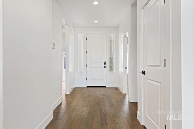 hallway with recessed lighting, dark wood finished floors, and baseboards