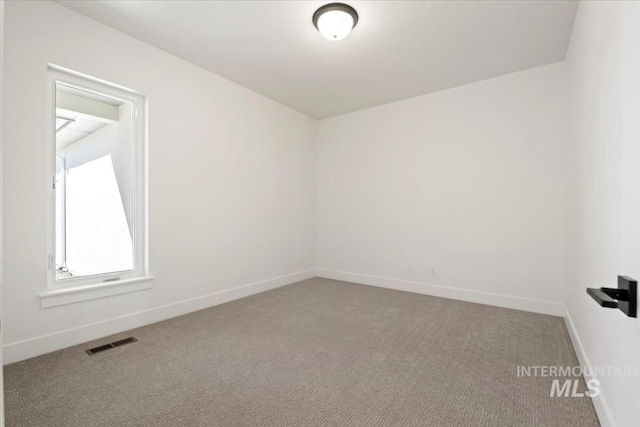 spare room featuring baseboards, carpet flooring, and visible vents