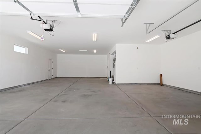 garage with baseboards and a garage door opener