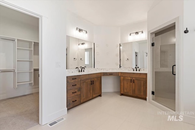 full bathroom featuring a spacious closet, visible vents, vanity, and a stall shower