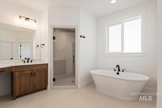 full bath with a shower stall, a freestanding bath, baseboards, and vanity