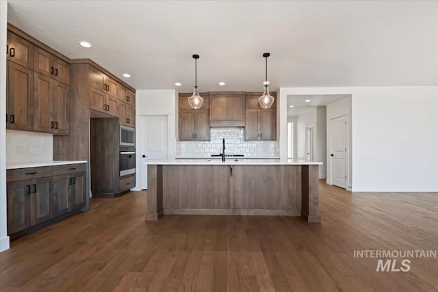 kitchen featuring backsplash, stainless steel appliances, a sink, and light countertops