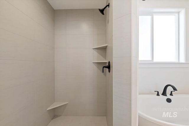 full bathroom featuring a freestanding bath and tiled shower