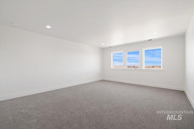 carpeted spare room featuring baseboards and recessed lighting