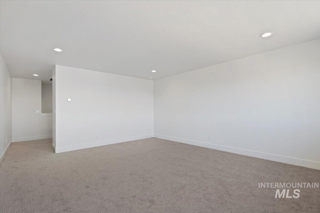 unfurnished room featuring baseboards, light carpet, and recessed lighting