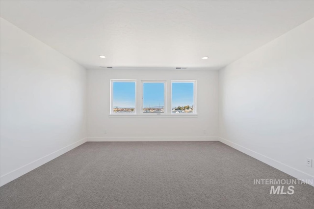 carpeted spare room with visible vents, baseboards, and recessed lighting