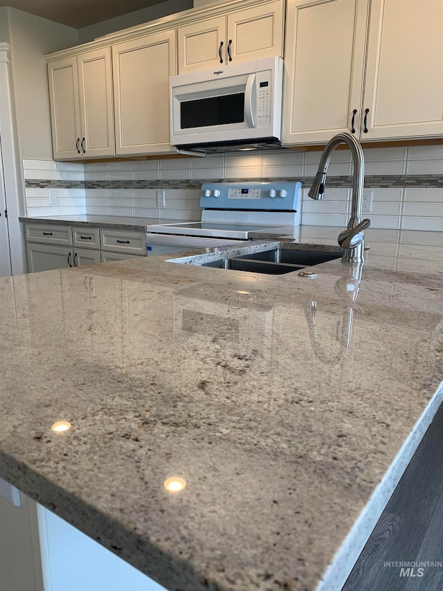 kitchen with tasteful backsplash, light stone countertops, and electric range