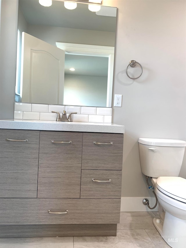 bathroom featuring toilet, large vanity, and tile flooring