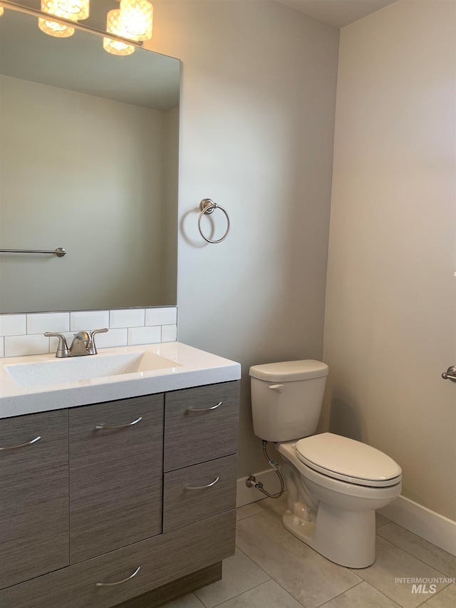 bathroom featuring vanity, tile floors, tasteful backsplash, and toilet