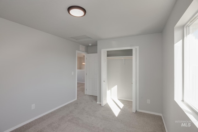 unfurnished bedroom featuring light carpet and a closet