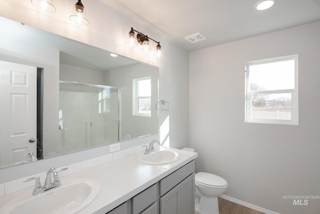 bathroom featuring hardwood / wood-style flooring, plenty of natural light, a shower with door, and vanity